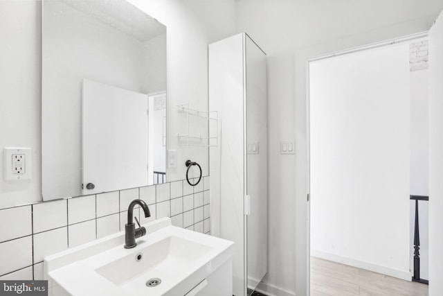 bathroom featuring vanity and decorative backsplash