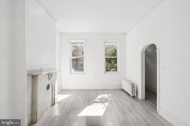 living room featuring radiator, ornamental molding, and light hardwood / wood-style floors