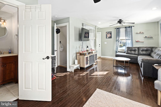 living room featuring sink, hardwood / wood-style flooring, and ceiling fan