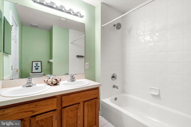 full bathroom featuring vanity, toilet, tiled shower / bath combo, and tile patterned flooring