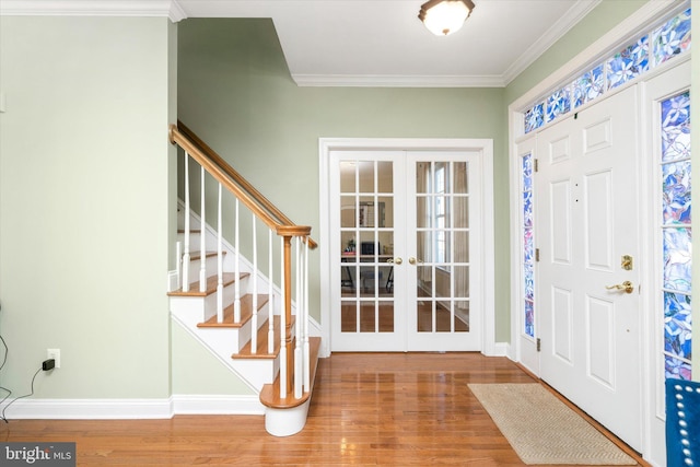 entrance foyer with french doors, crown molding, and hardwood / wood-style floors