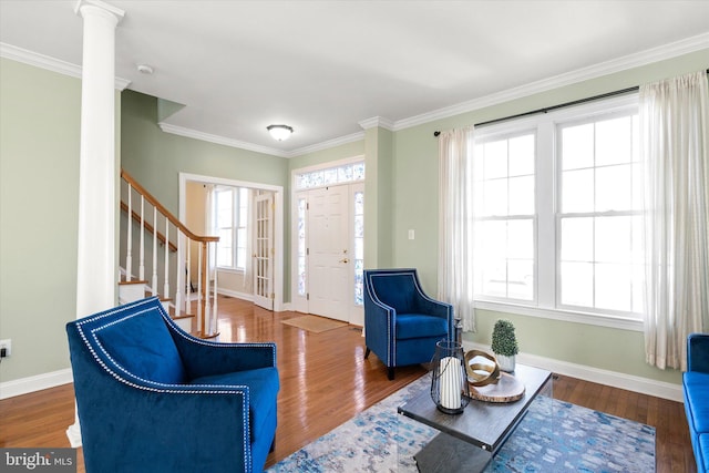 interior space featuring crown molding, wood-type flooring, and ornate columns