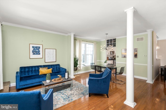 living room with hardwood / wood-style flooring, ornamental molding, and decorative columns