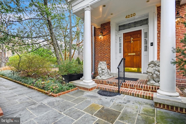 property entrance with brick siding and a porch