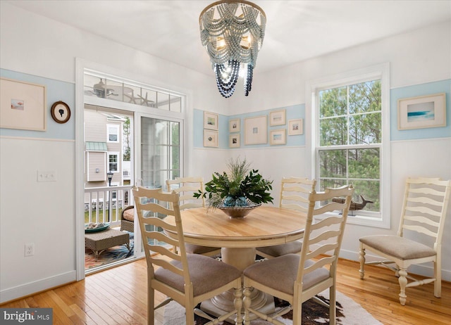 dining space with a notable chandelier, light hardwood / wood-style flooring, and a healthy amount of sunlight