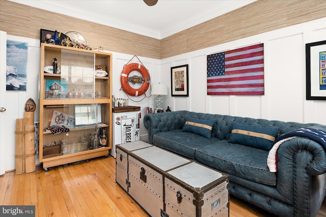 living room with ornamental molding and light hardwood / wood-style flooring