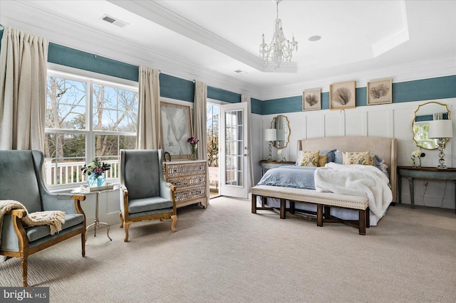 carpeted bedroom with multiple windows, a notable chandelier, ornamental molding, and a raised ceiling