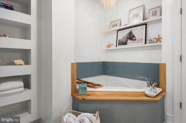 bathroom with a bathing tub and built in shelves