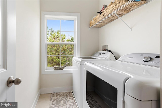 washroom featuring washing machine and dryer and light tile patterned floors