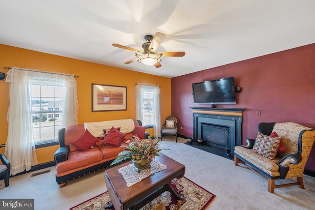 carpeted living room with ceiling fan
