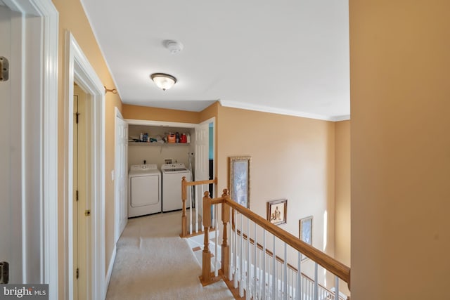 corridor with light carpet, crown molding, and washing machine and dryer