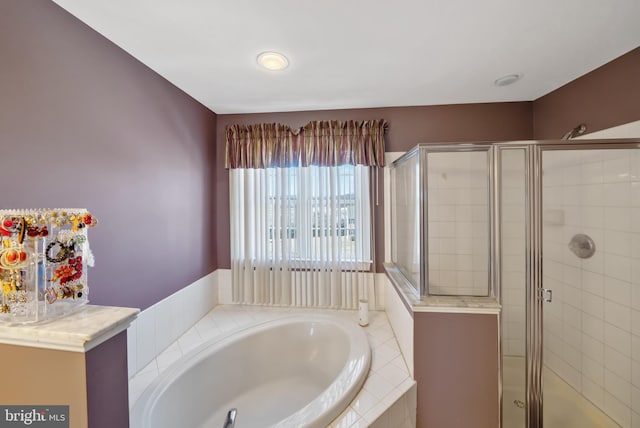 bathroom featuring shower with separate bathtub