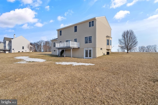 back of property featuring a wooden deck and a yard