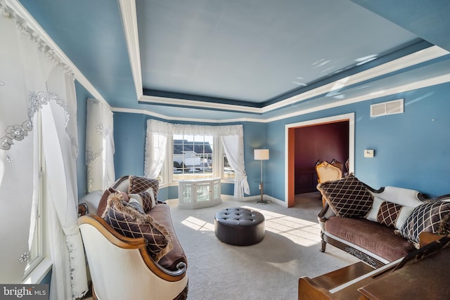 living room with crown molding, a tray ceiling, and carpet flooring