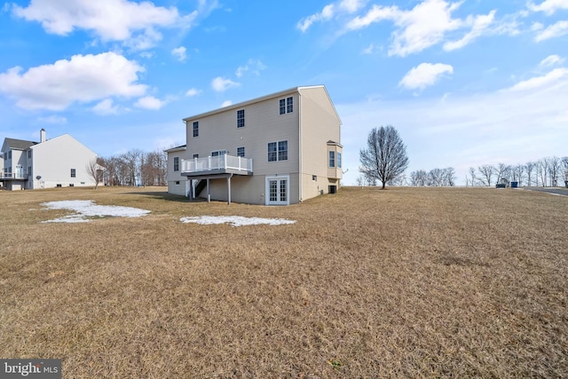 rear view of house featuring a wooden deck and a yard