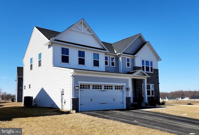 view of front of property featuring a garage, central AC, and a front lawn