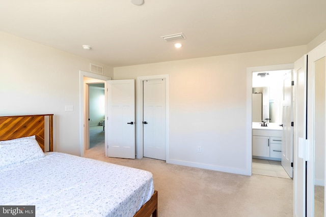 carpeted bedroom featuring a closet and connected bathroom