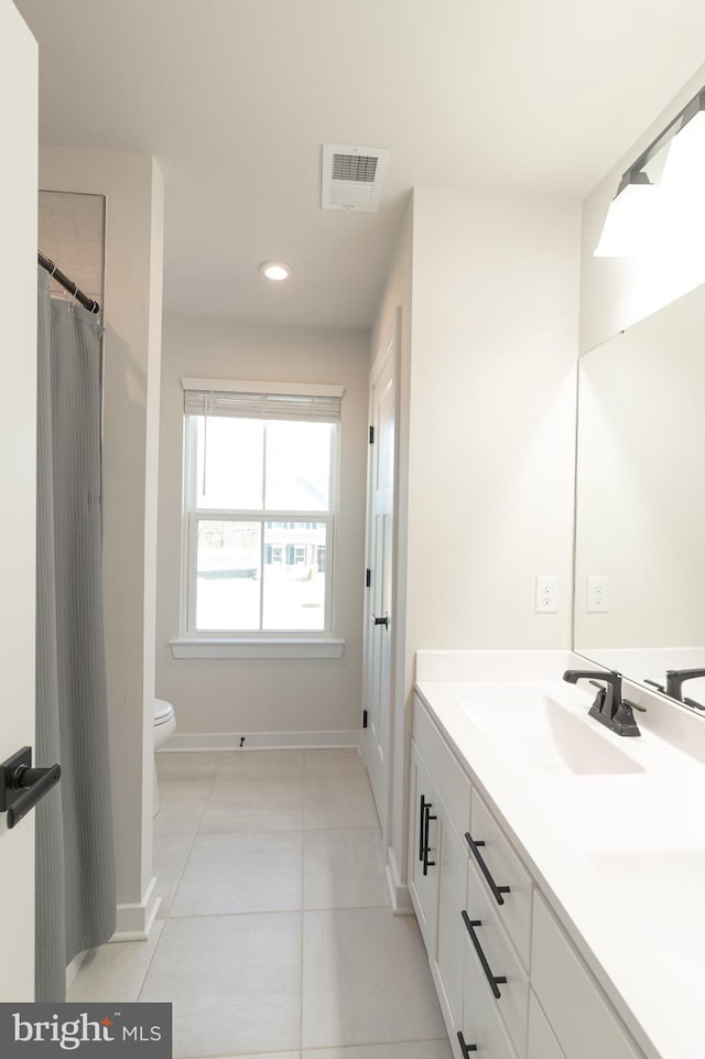 bathroom with vanity, toilet, and tile patterned floors