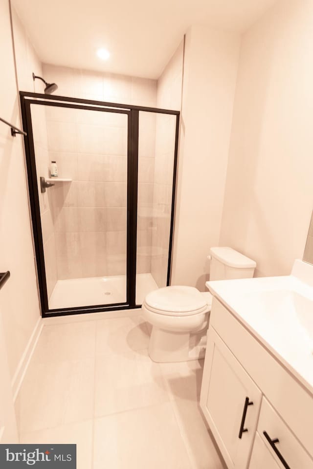 bathroom featuring toilet, a shower with shower door, vanity, and tile patterned flooring