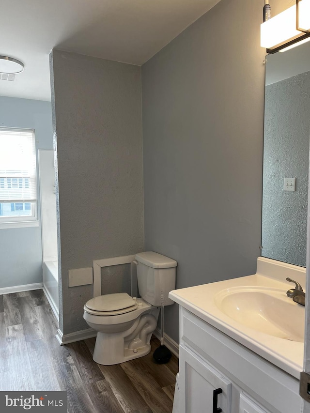 bathroom with hardwood / wood-style flooring, vanity, and toilet