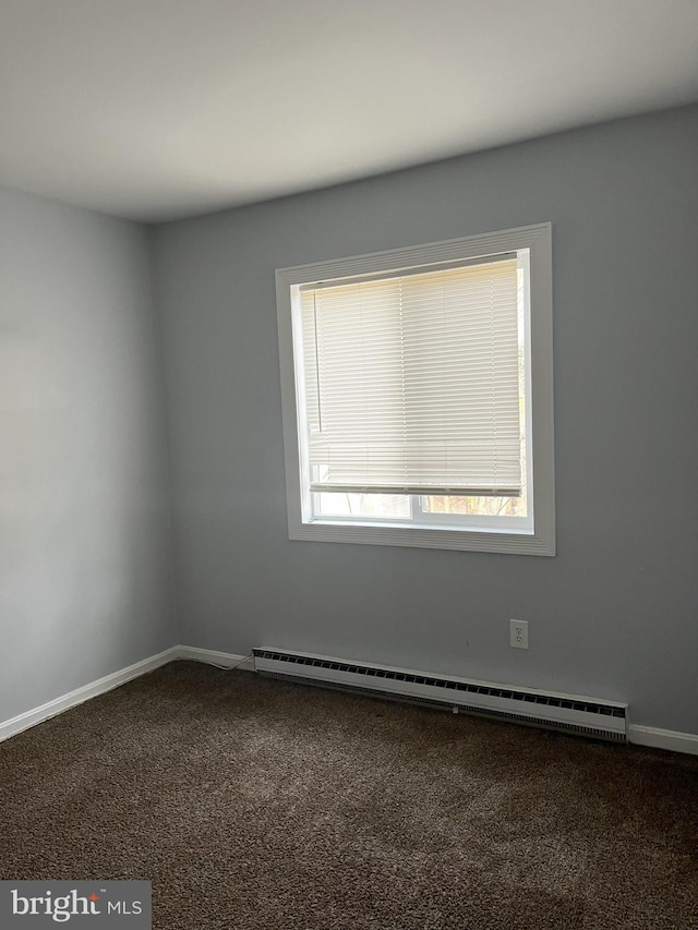 carpeted spare room with a baseboard radiator