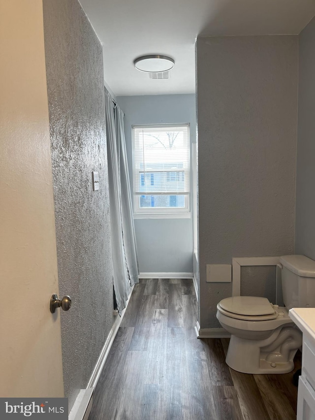 bathroom featuring wood-type flooring, vanity, and toilet