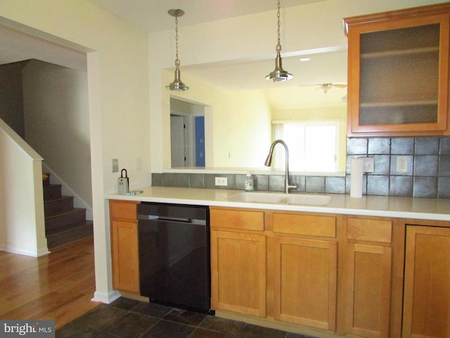 kitchen featuring tasteful backsplash, decorative light fixtures, black dishwasher, and sink