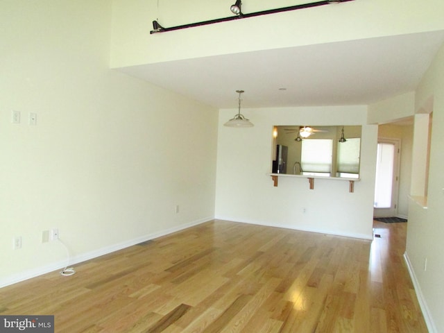 empty room with ceiling fan and light hardwood / wood-style flooring