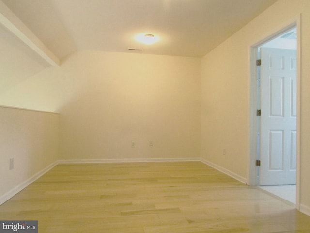 additional living space with hardwood / wood-style flooring and vaulted ceiling