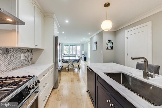 kitchen featuring light stone countertops, sink, pendant lighting, and white cabinets