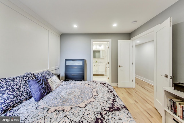 bedroom with light wood-type flooring and ensuite bath