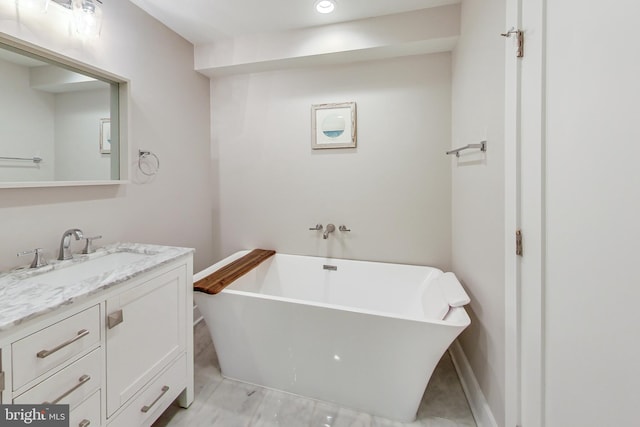 bathroom featuring vanity and a washtub