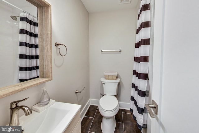 bathroom with sink, curtained shower, and toilet