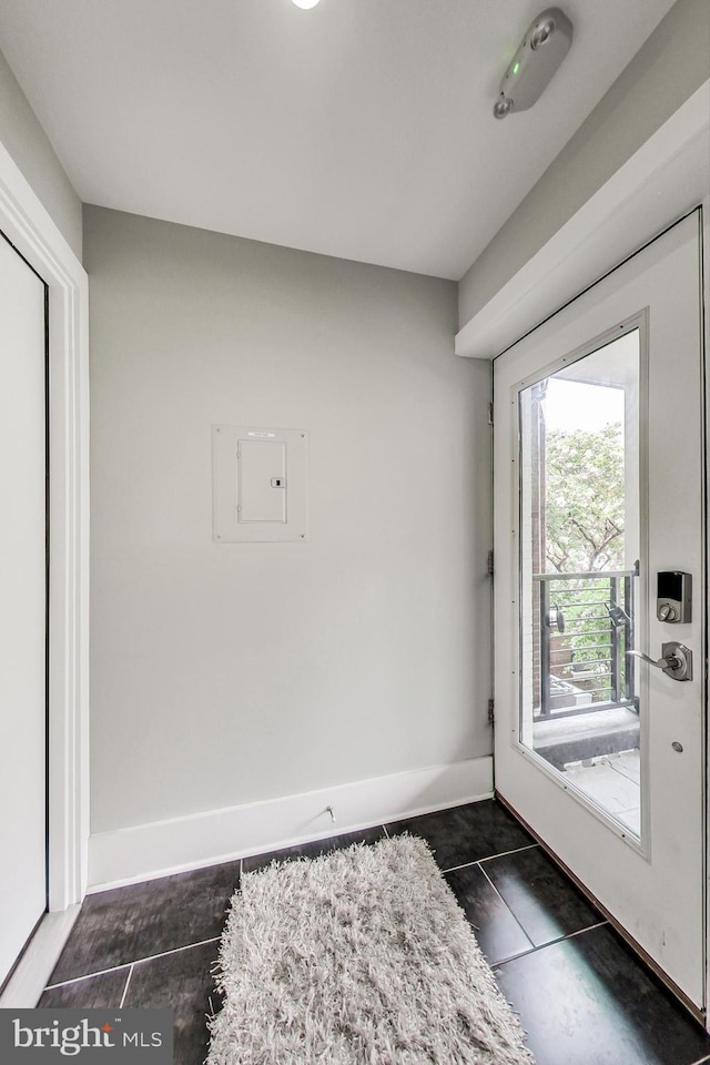 doorway featuring dark tile patterned floors and electric panel