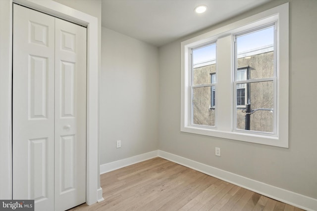 unfurnished bedroom with light hardwood / wood-style floors and a closet