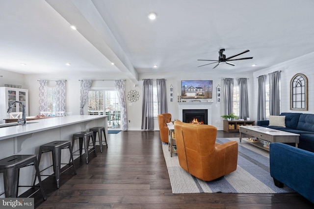 living room with a healthy amount of sunlight, sink, and dark hardwood / wood-style flooring