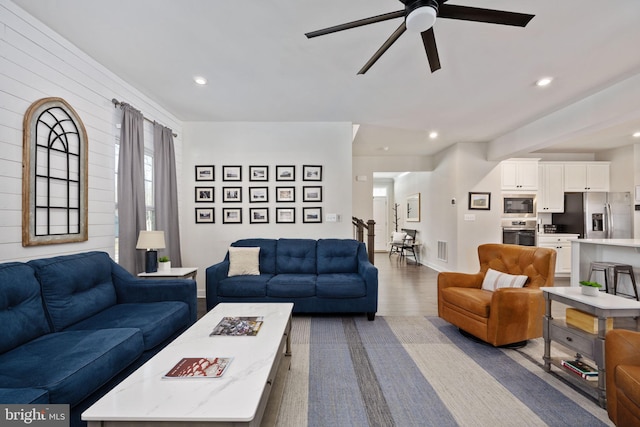 living room featuring hardwood / wood-style floors and ceiling fan