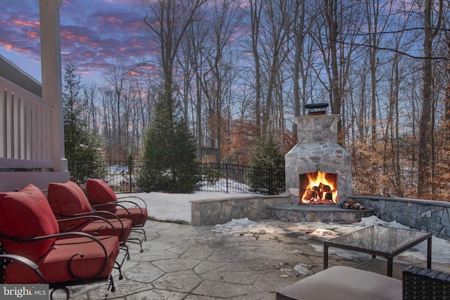 patio terrace at dusk with an outdoor stone fireplace