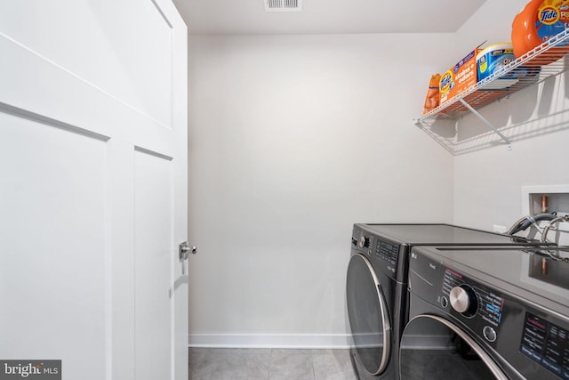 clothes washing area with light tile patterned floors and washing machine and dryer