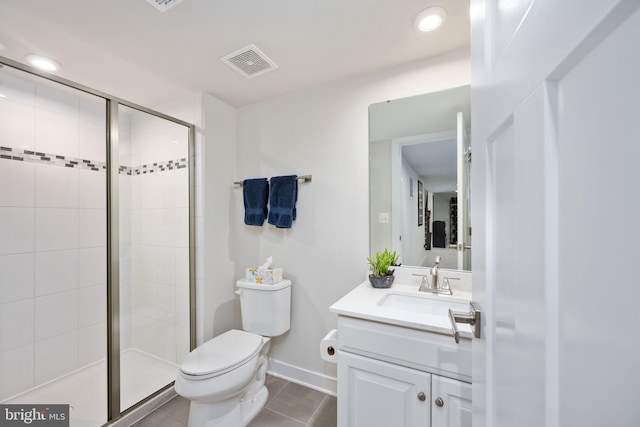 bathroom featuring vanity, toilet, a shower with door, and tile patterned flooring