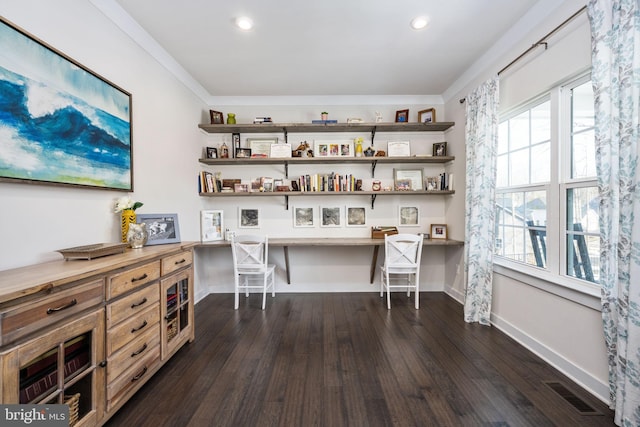 home office with built in desk, ornamental molding, and dark hardwood / wood-style floors