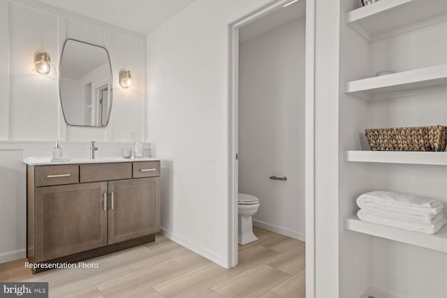 bathroom featuring vanity, toilet, and wood-type flooring