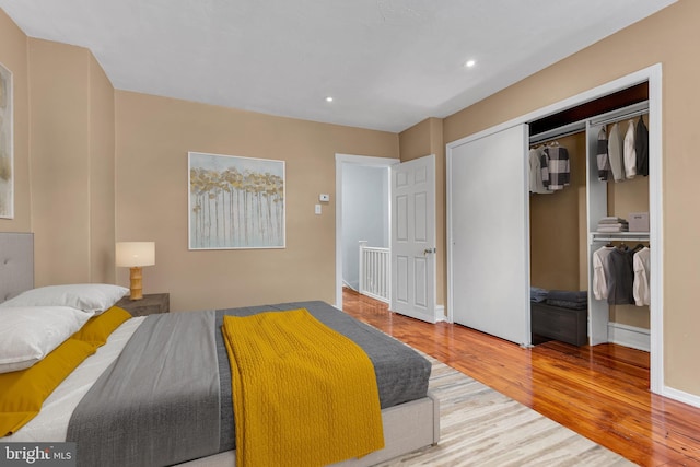 bedroom featuring a closet, recessed lighting, baseboards, and wood finished floors