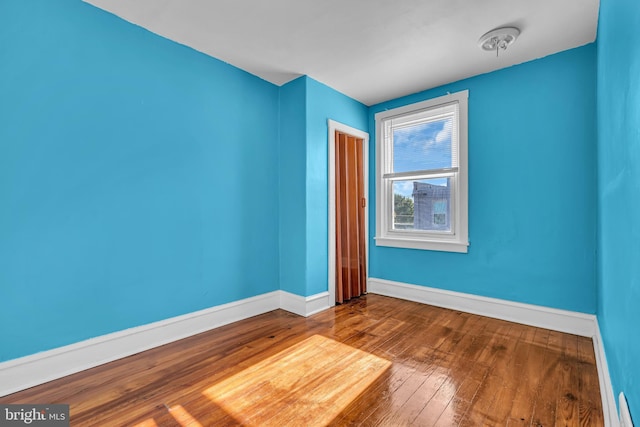 empty room featuring baseboards and wood-type flooring