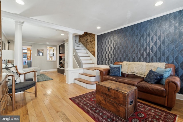 living room with ornate columns, ornamental molding, and light hardwood / wood-style floors