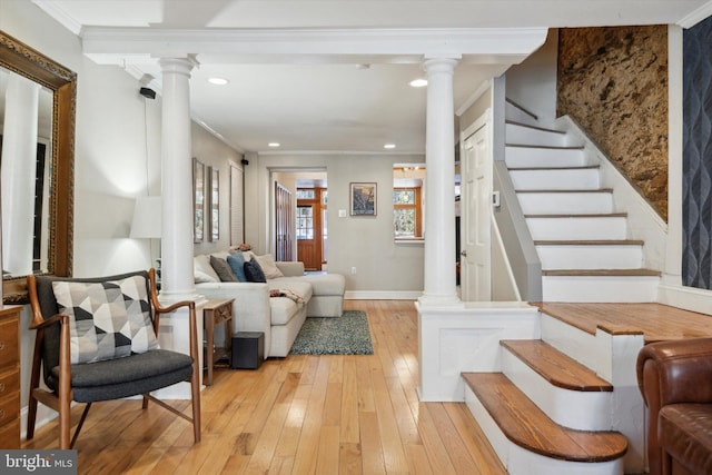 interior space featuring ornate columns, crown molding, and light hardwood / wood-style flooring