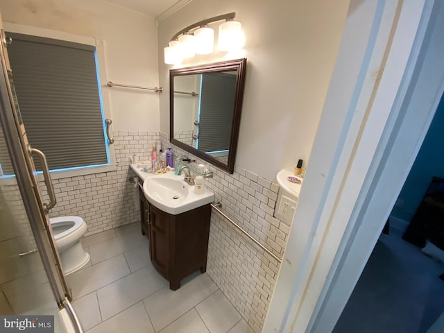 bathroom with toilet, crown molding, tile walls, vanity, and tile patterned flooring