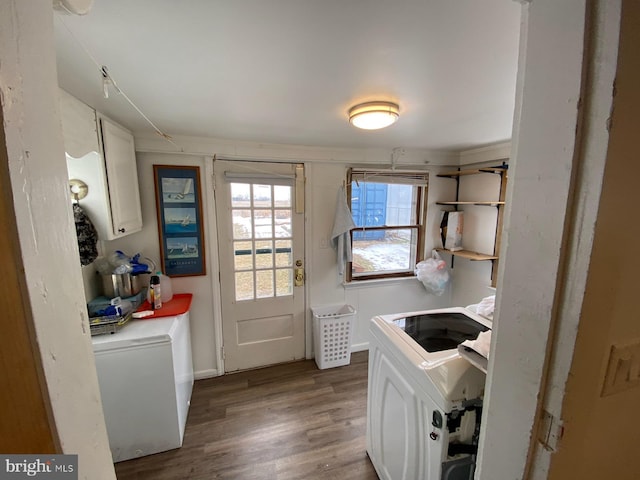 laundry room with wood-type flooring and washing machine and dryer