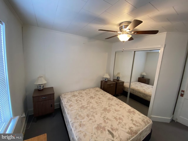 bedroom featuring crown molding, ceiling fan, and a closet