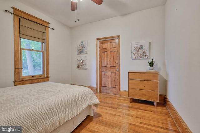 bedroom with baseboards, ceiling fan, and light wood-style floors